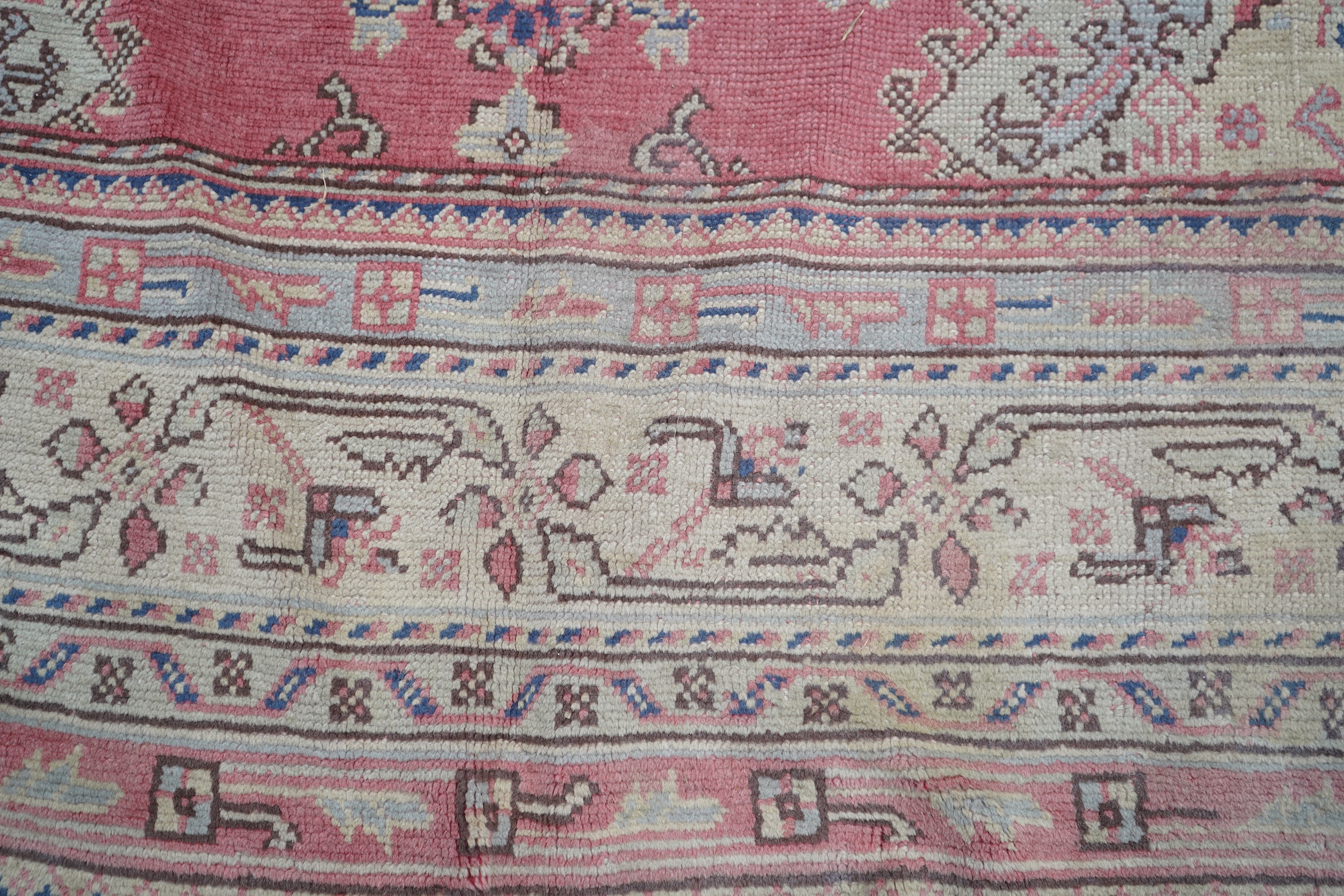 A large Turkish faded red ground carpet